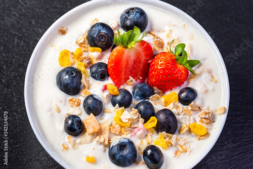 Yogurt with granola  strawberries and blueberries.