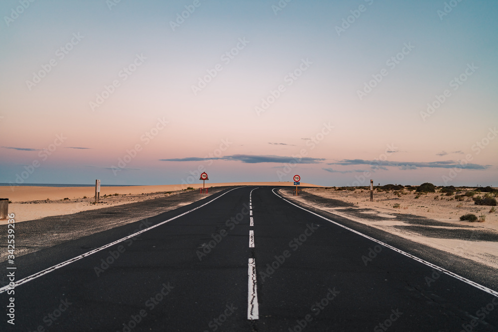 Fototapeta premium Beautiful road in the desert of Fuerteventura, Canary Islands at sunset