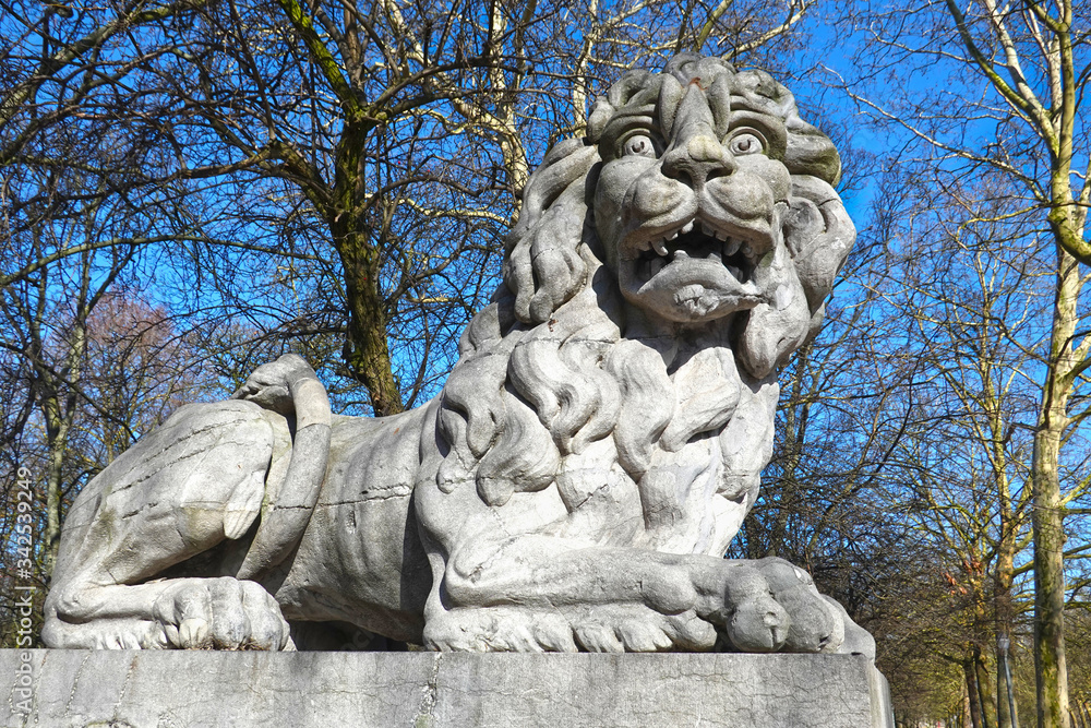 Terrified looking lion, sculpture by Joseph Dubois, 1780, at the gate of the Brussels Park (Parc de Bruxelles), opposite of the Royal Palace, Brussels, Belgium