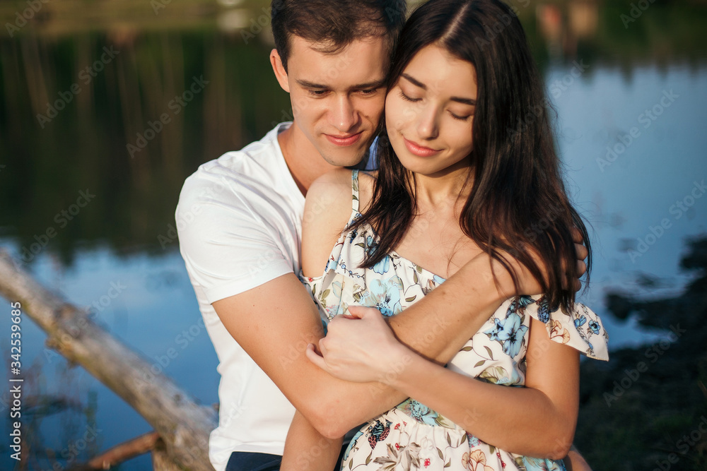 Young loving couple hugging near lake. Young loving couple hugging near lake.