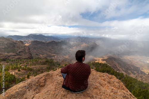 Man standing on cliff with view of beautiful mountains in Gran Canaria
