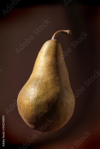 Fresh floating pear on brown background