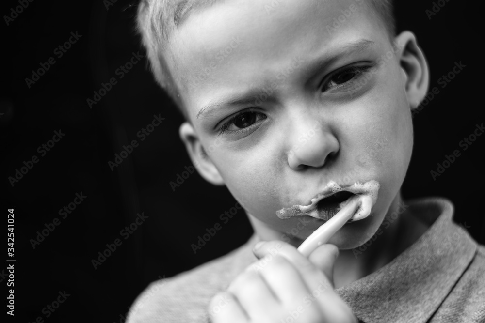 the child is brushing his teeth. black and white portrait of a preschooler the child is brushing his teeth. black and white portrait of a preschooler