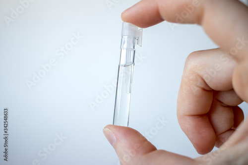 Hand holding perfume vial photo