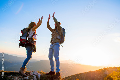 Couple on Top of a Mountain Shaking Raised Hands