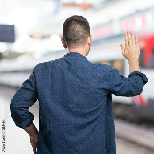 Young man wearing a blue outfit. Doing stop gesture.