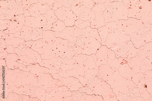 Texture of a concrete pink, wall with bumps, cracks, splashes. Abstract background. Copy space