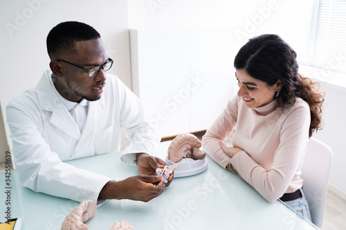 Doctor Explaining Details Of Human Brain To Woman