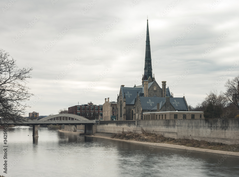 Old Historic Church beside a river with a bridge during cloudy weather Old Historic Church beside a river with a bridge during cloudy weather