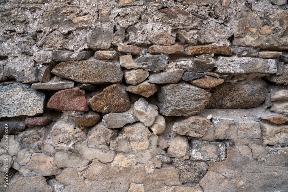 Stone Wall Texture Background with asymmetrical stones stacked together to form a vintage wall Stone Wall Texture Background with asymmetrical stones stacked together to form a vintage wall
