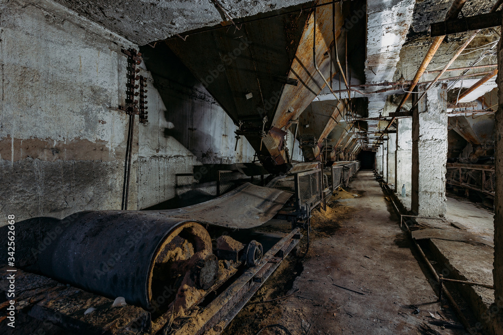 Abandoned cement and concrete factory. Old conveyor and rusty hoppers