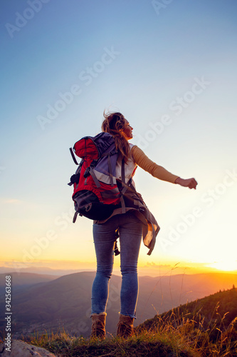 Portrait of happy young woman hiking in the mountains