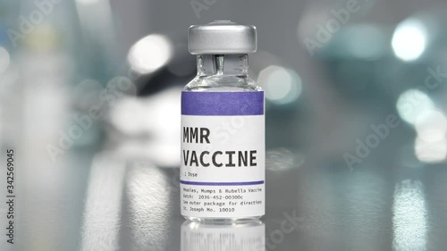 MMR measles, mumps, and rubella vaccine vial in medical lab slowly rotating. photo