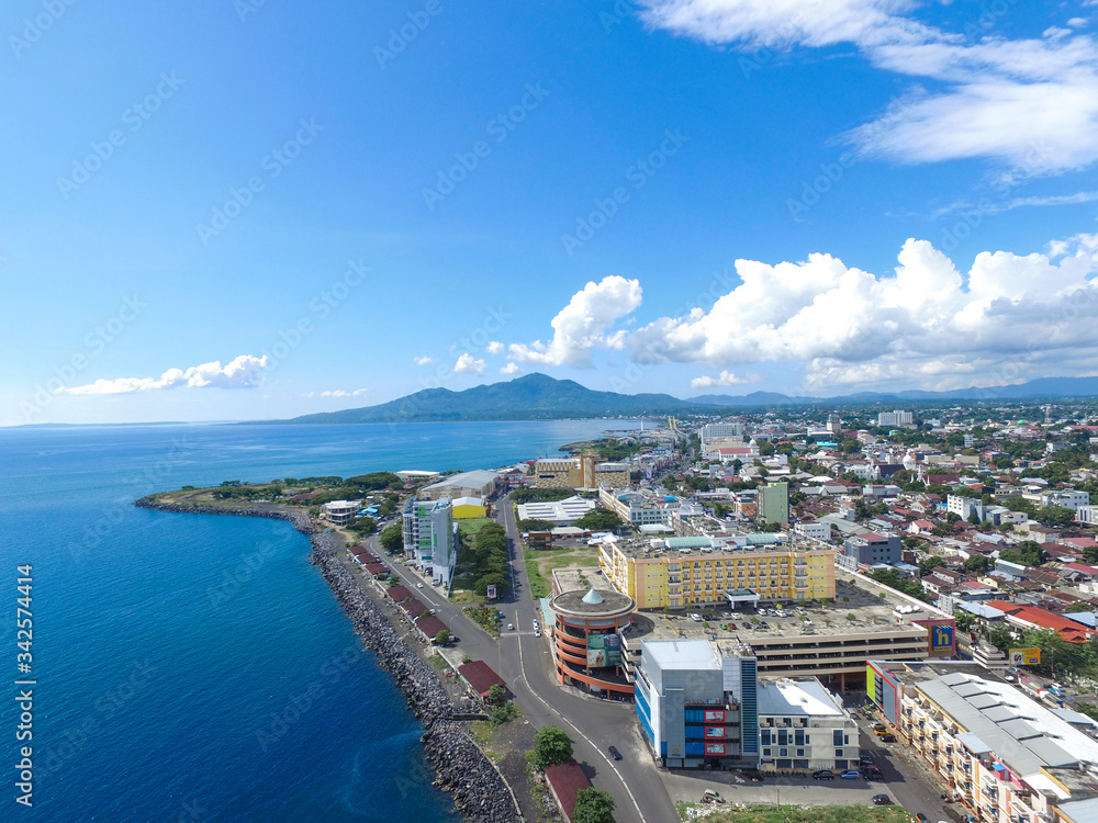 Manado Indonesia June 28, 2020 : Aerial skyscrapers marina in the sunny day with front line of office, home, urban city Manado Indonesia