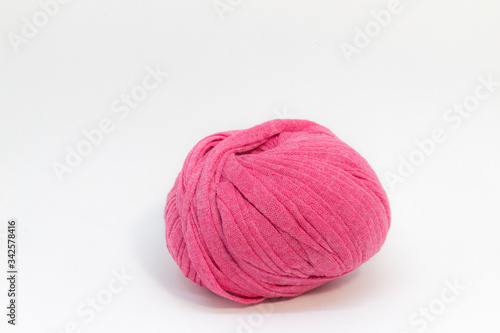 Pink wool ball for knitting on white background.