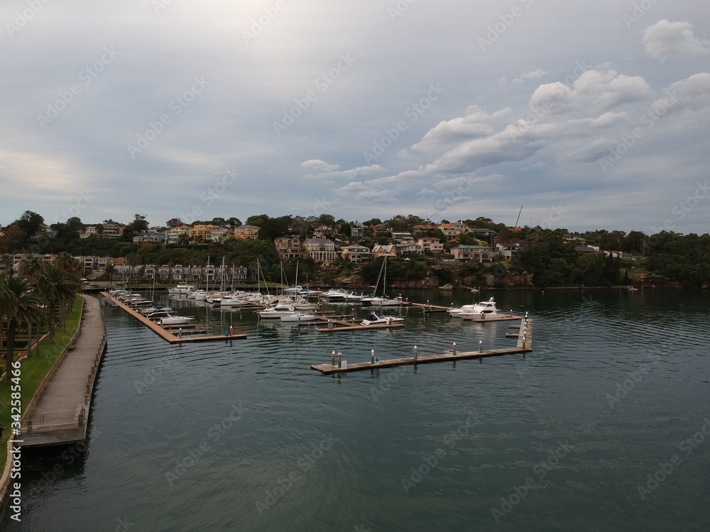 Panoramic drone aerial view over Sydney harbour on a cloudy sunset showing the nice colours of the harbour foreshore