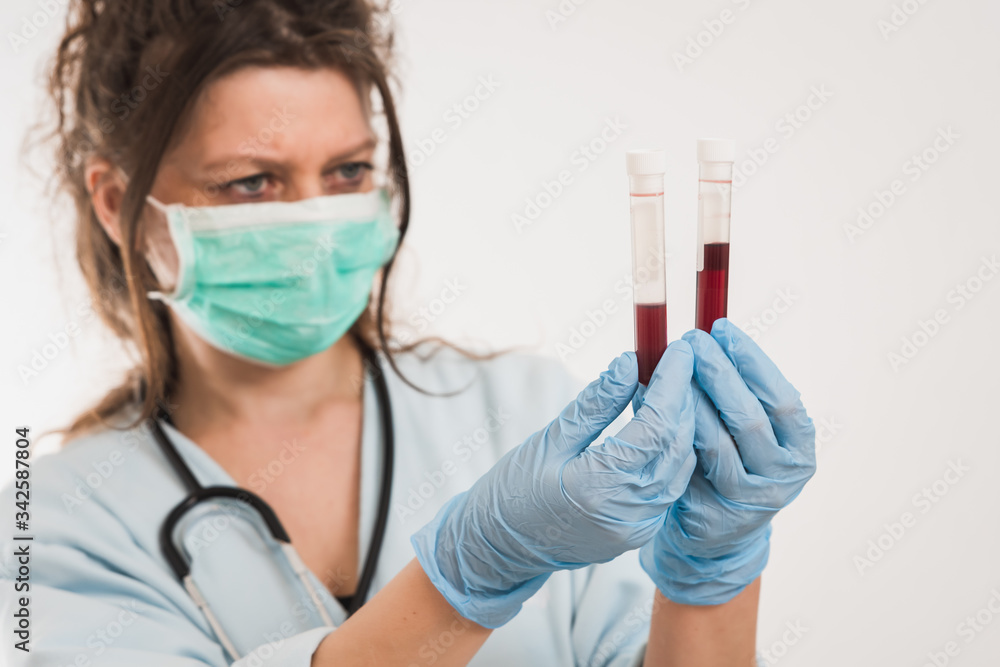 young female doctor is manipulating the blood test tube young female doctor is manipulating the blood test tube