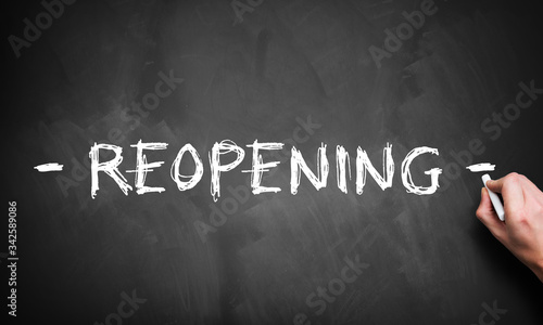 hand writing REOPENING on blackboard