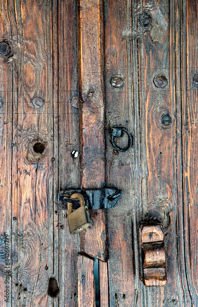 Old wooden door with an iron lock and a bolt in the monastery of the Holy Cross. Omodos village. Cyprus Old wooden door with an iron lock and a bolt in the monastery of the Holy Cross. Omodos village. Cyprus