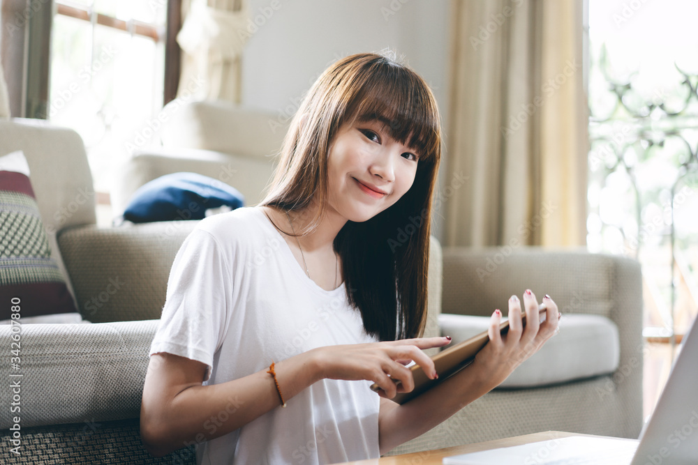 Student study online stay at home for social distancing concept. Young asian woman learning and exam via internet with laptop and tablet. Living room background with window light. Student study online stay at home for social distancing concept. Young asian woman learning and exam via internet with laptop and tablet. Living room background with window light.