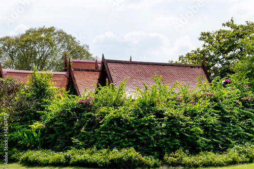 Big and beautiful old Thai style house' roof structure with the green yard of Sampran riverside hoter. Nakornpathom, Thailand September 30, 2017