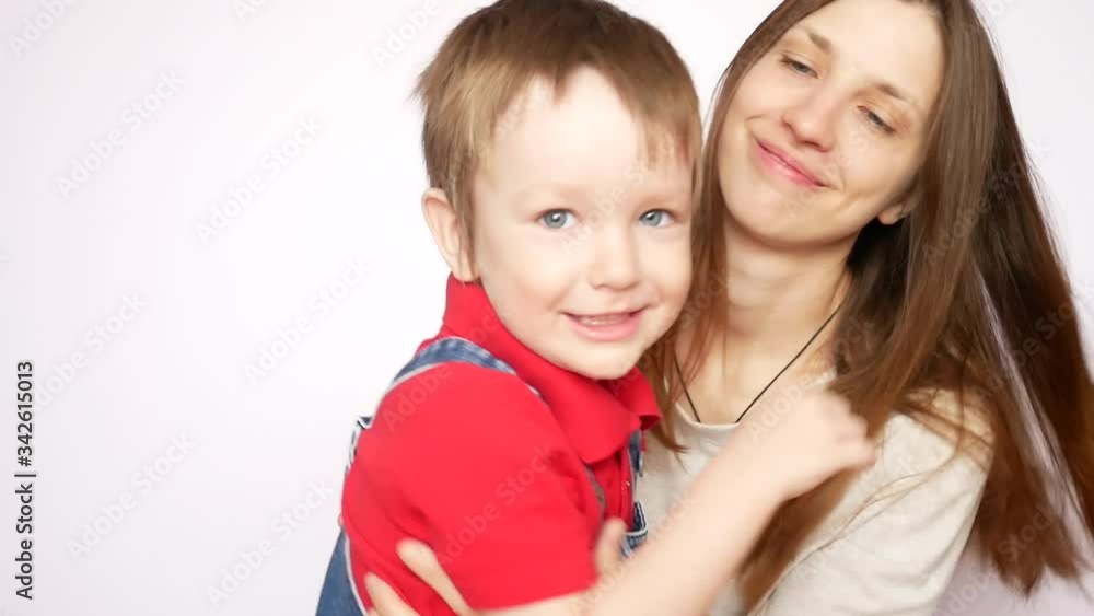A young beautiful lady embraces and kisses her little son A young beautiful lady embraces and kisses her little son