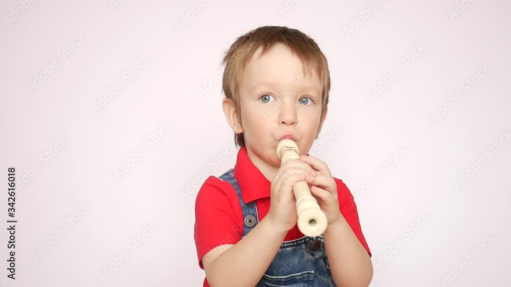 One cute little boy plays flute and jumps One cute little boy plays flute and jumps