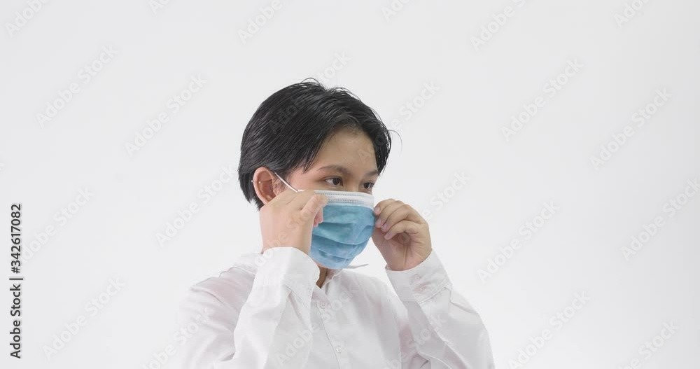 Asian woman putting on surgical face mask for protection against coronavirus on white background
Asian woman putting on surgical face mask for protection against coronavirus on white background