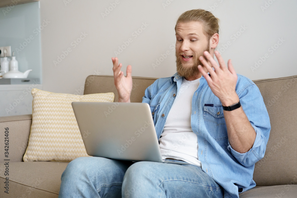 Young man video calling on laptop chatting with distance friend sit on sofa working studying from home office on quarantine. Male distance worker student doing online virtual webcam chat on computer. Young man video calling on laptop chatting with distance friend sit on sofa working studying from home office on quarantine. Male distance worker student doing online virtual webcam chat on computer.