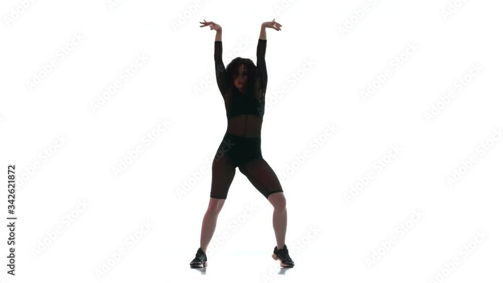 young beautiful woman in a black transparent tight suit energetically dancing dancehall, street dance, twerk against white background, isolated young beautiful woman in a black transparent tight suit energetically dancing dancehall, street dance, twerk against white background, isolated