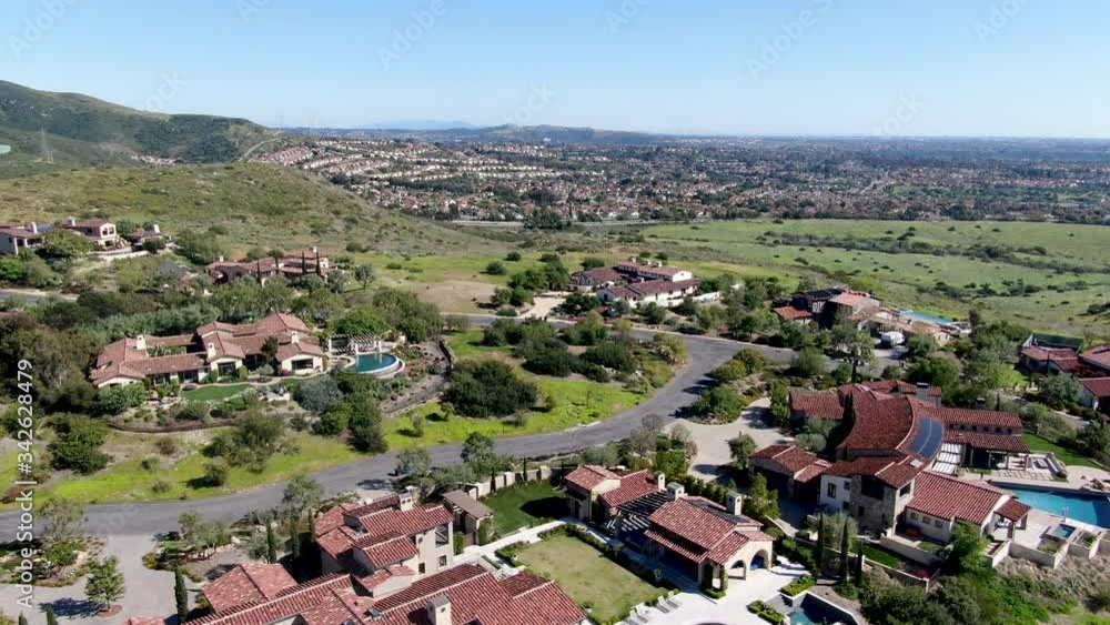 Aerial view of big luxury villa with pool located next the golf course and green valley in a private community, San Diego, California. Aerial view of big luxury villa with pool located next the golf course and green valley in a private community, San Diego, California.