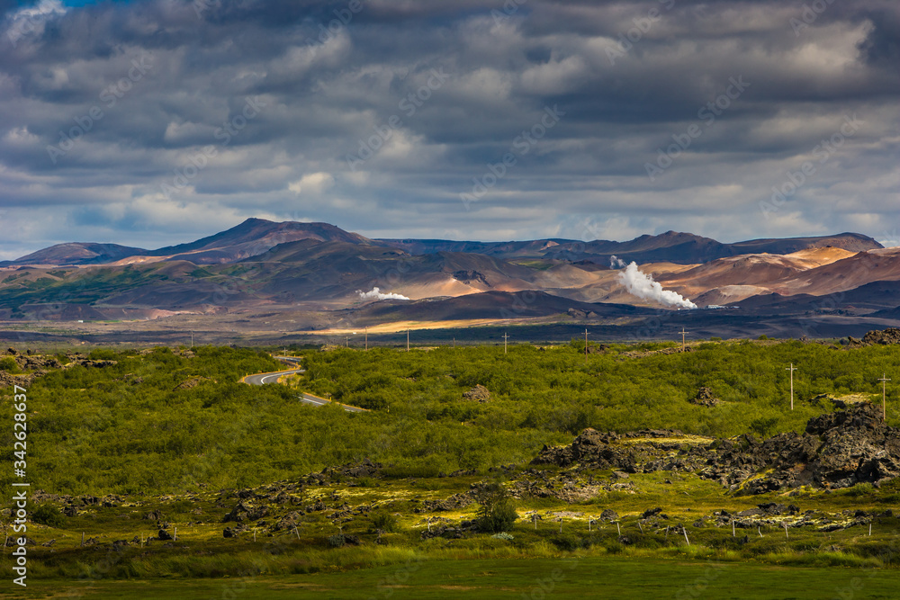 Beautiful colourful Icelandic landscape lava fields mountain geysers zigzag road and moss-covered stones Namafjall, Iceland. Beautiful colourful Icelandic landscape lava fields mountain geysers zigzag road and moss-covered stones Namafjall, Iceland.