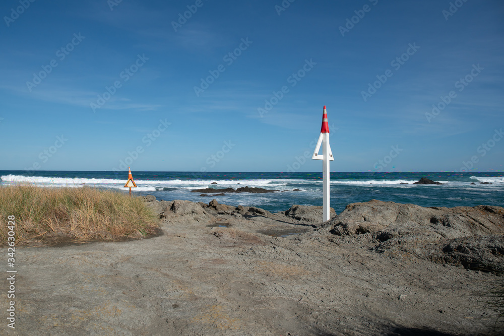 Two Maritime sign posts embedded in the coast rock warning sea vessels
