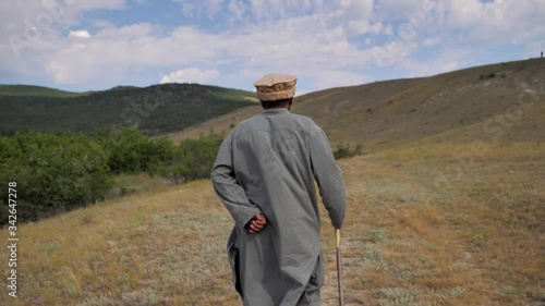 Behind. Mountains Of Afghanistan. Old Pashtun man walks through a desolate area