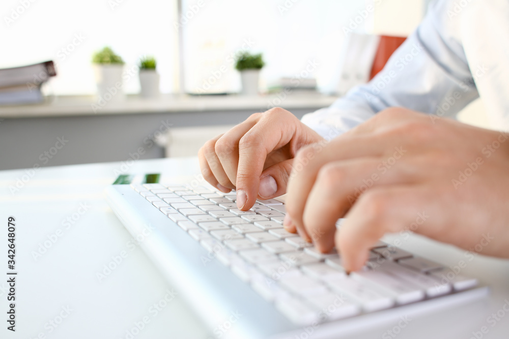 Male arms in suit typing on white keyboard using computer pc at office workplace closeup. Accountant finger job modern lifestyle web search assistant enter account login password and note credential Male arms in suit typing on white keyboard using computer pc at office workplace closeup. Accountant finger job modern lifestyle web search assistant enter account login password and note credential
