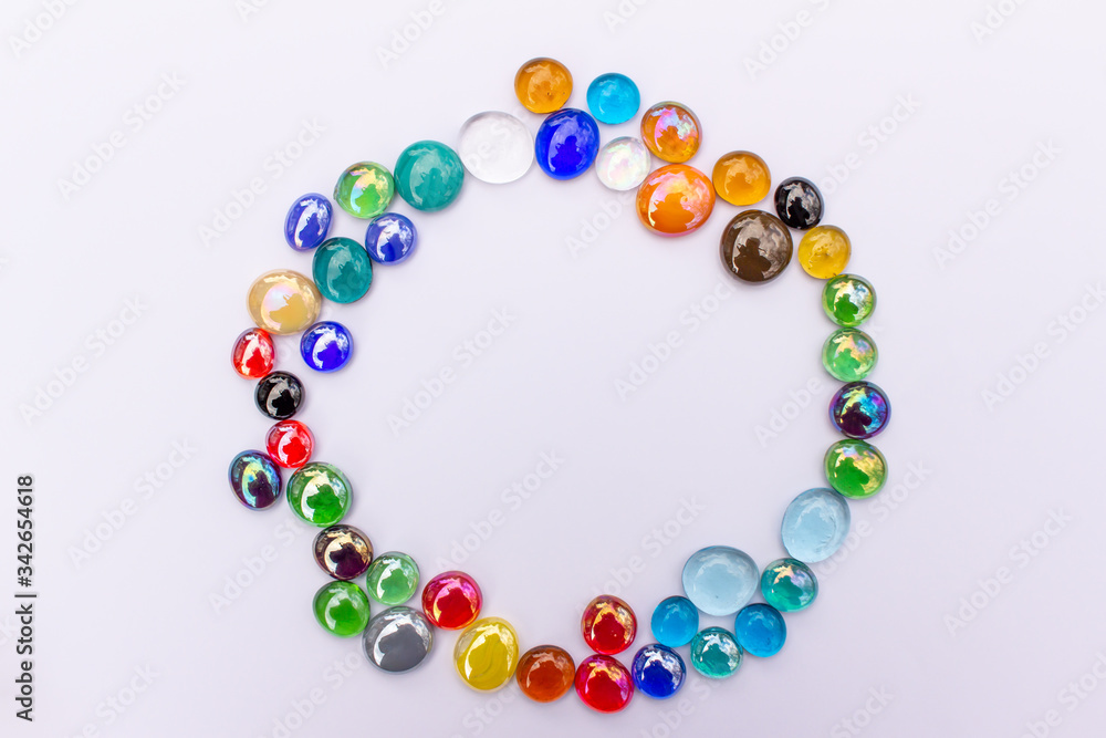 Abstract art round design background of colorful glass drop dragon tears on a light neutral background with copy space