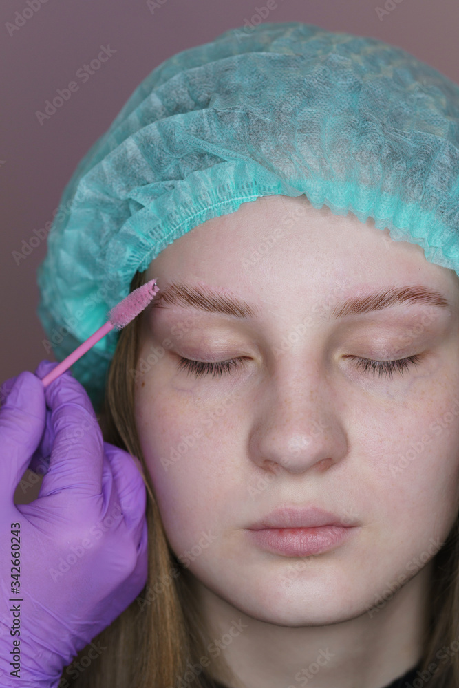 Long-lasting eyebrow styling. Eyebrow biolamination. Master gives right shape to eyebrows for hair growth. Cosmetic procedure in spa salon. Beautician at work.. Long-lasting eyebrow styling. Eyebrow biolamination. Master gives right shape to eyebrows for hair growth. Cosmetic procedure in spa salon. Beautician at work..