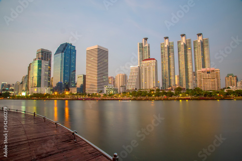 Beautiful Cityscape of office building with water reflection at Benjakitti park  Bangkok Thailand. Panorama of the office building in the evening with sunset.