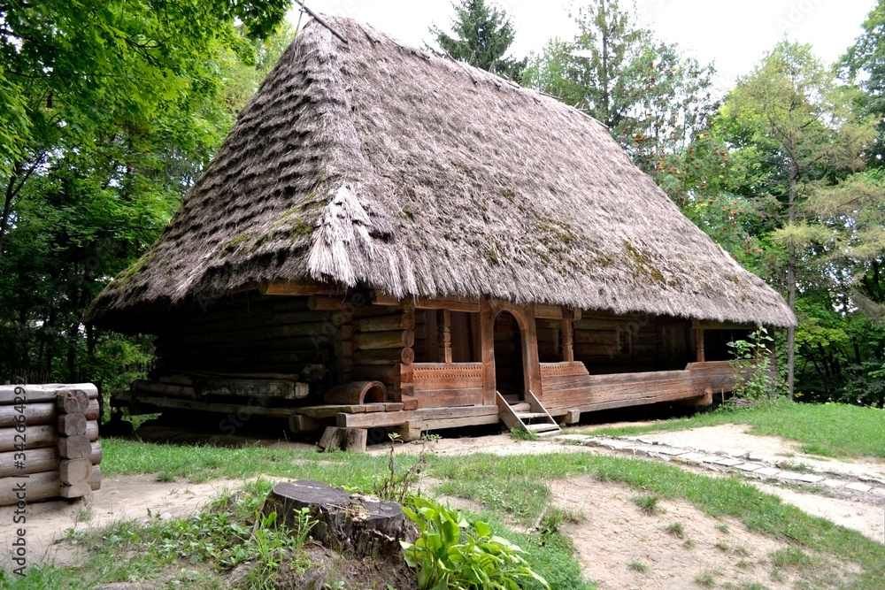 Traditional ukrainian village house.  Wooden house with thatched roof in the countryside.