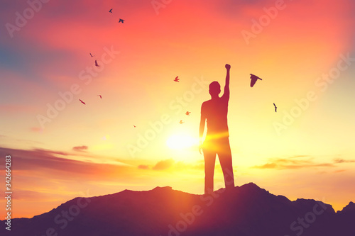 Copy space of man raise hand up on top of mountain and sunset sky abstract background. © tonktiti