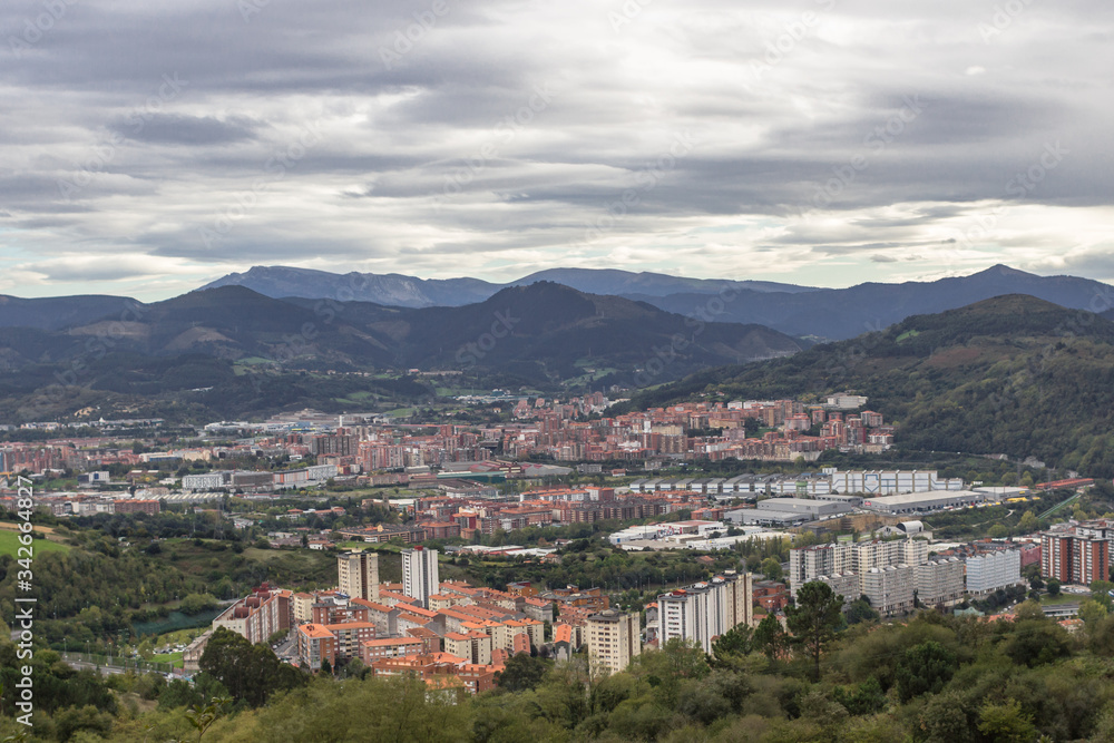 The largest city of the Basque Country. Top view on Bilbao. Panorama of the big city. Red tiles of a European resort town. Roofs of houses. City at the foot of the mountains.