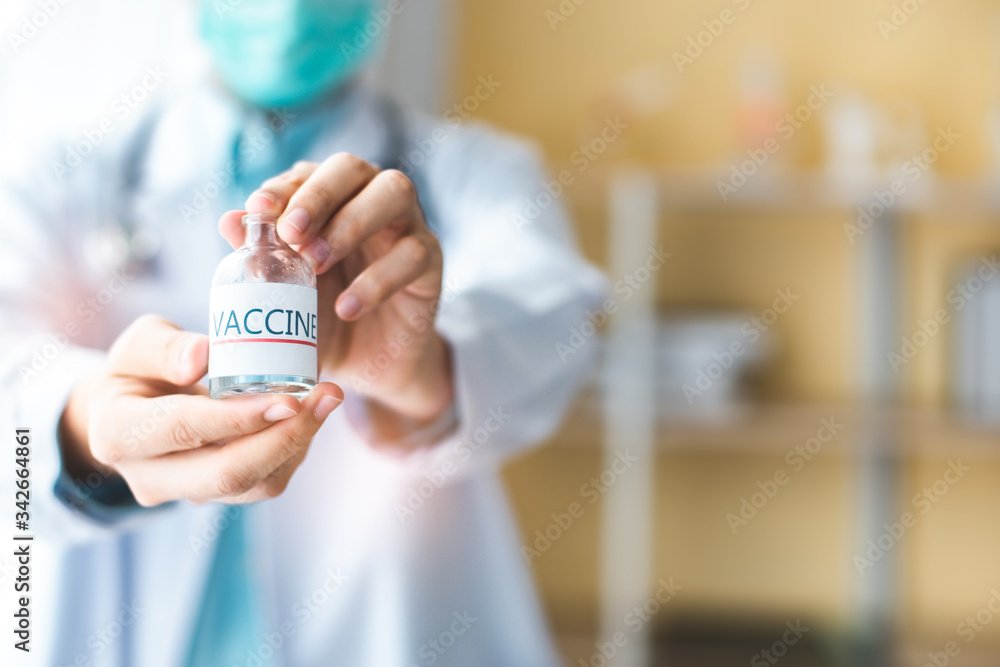 A doctor or scientist in laboratory holding a syringe with liquid vaccines for children or older adults, or cure animal diseases.Close up of a Doctor holding a vaccine. A doctor or scientist in laboratory holding a syringe with liquid vaccines for children or older adults, or cure animal diseases.Close up of a Doctor holding a vaccine.