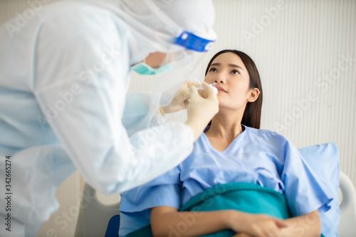  Medicine and health care concept. Asian doctor is taking care patient woman in hospital.doctor or nurse wear protection mask checking and takecare infection people from covid-19 .