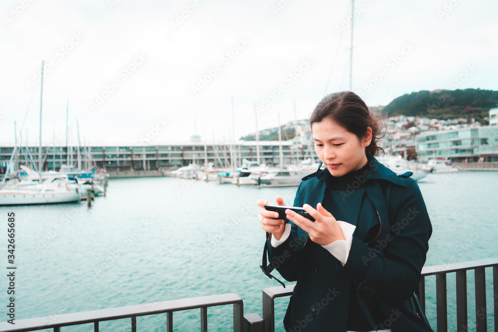 Woman using smartphone on Wellington waterfront