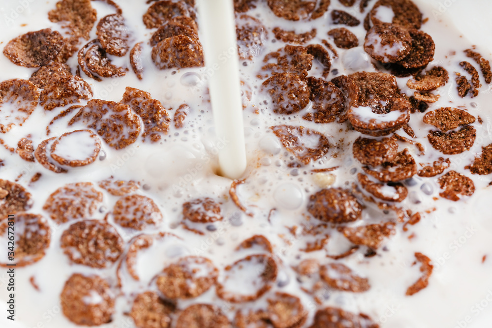 Bowl of chocolate flakes with milk splash. Top view. Bowl of chocolate flakes with milk splash. Top view.