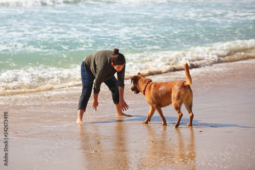 Teenage girl with her dog on the beach