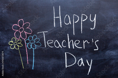 Happy Teachers Day written in chalkboard with white chalk photo