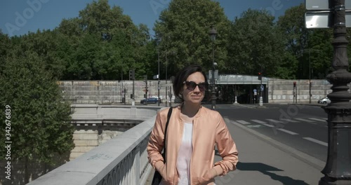 Traveling of a Woman walking on a bridge at Paris during the summer