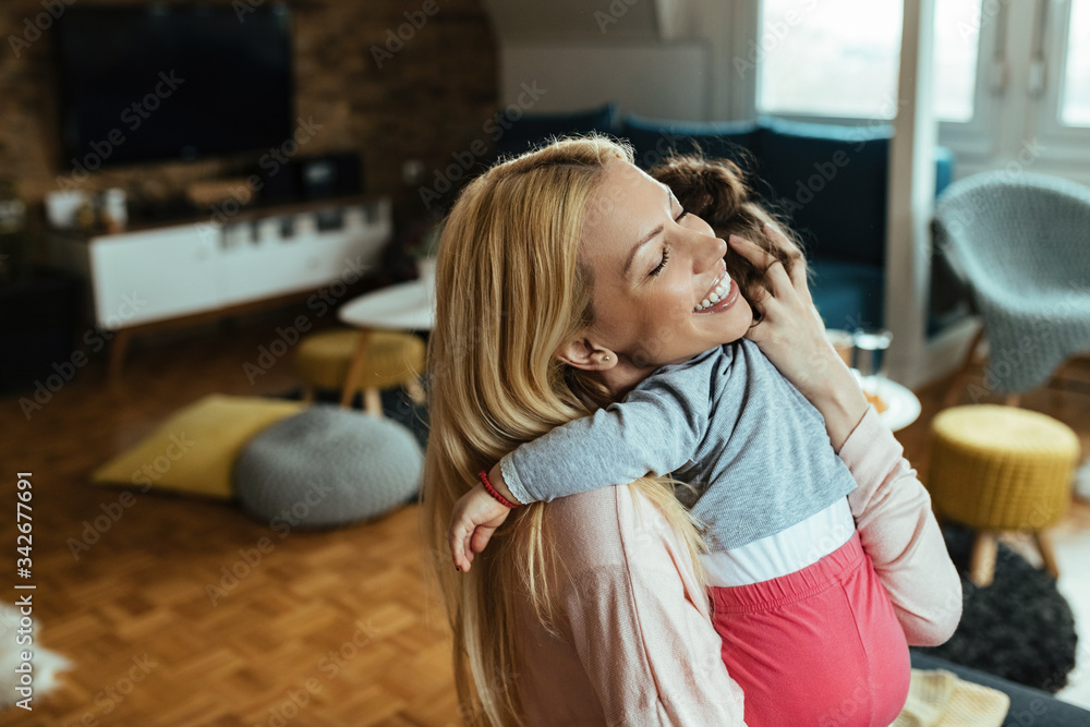 Affectionate mother embracing her small daughter at home. Affectionate mother embracing her small daughter at home.