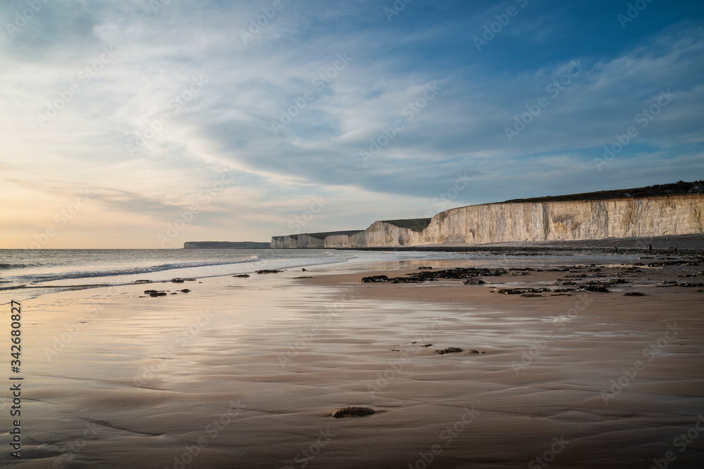 Stunning landscape image of white chalk cliffs with colorful vibrant sunset on English coast
